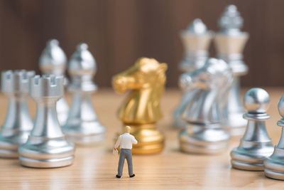 Close-up of chess pieces and figurine on table