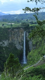 Scenic view of waterfall against sky