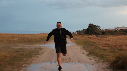 Man with headphone running outdoor during rain day