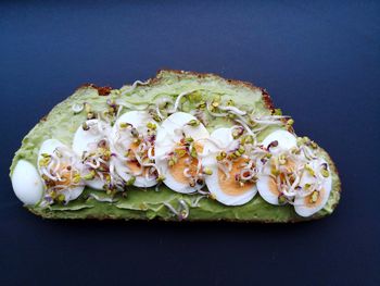 Close-up of avocado bread on plate against black background