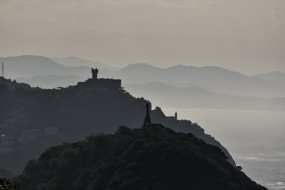 Buildings against sky with mountain in background