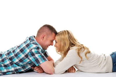 Rear view of couple kissing against white background