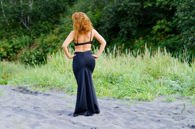Rear view of woman standing on grass