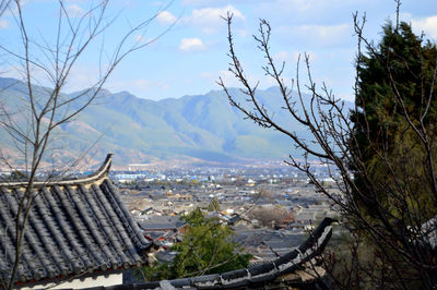 Aerial view of cityscape and mountains against sky