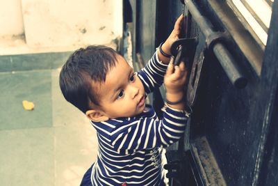 High angle view of cute baby girl opening gate