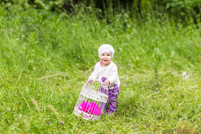Portrait of cute girl holding basket in field