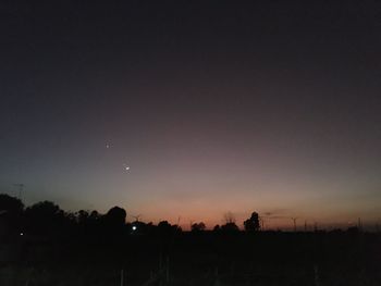 Silhouette landscape against clear sky at night