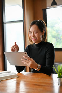 Young woman using laptop at table