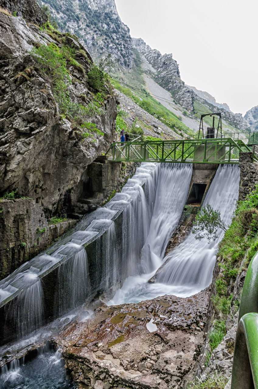 waterfall, water, flowing water, mountain, motion, flowing, scenics, beauty in nature, long exposure, rock - object, nature, river, idyllic, bridge - man made structure, connection, rock formation, railing, forest, day, tranquil scene