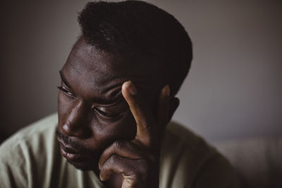 Close-up of sad man holding head in hand while looking away