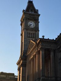 Low angle view of clock tower against clear sky