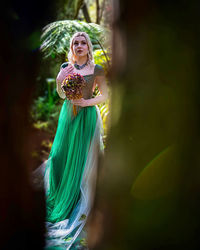 Portrait of young woman standing against blurred background