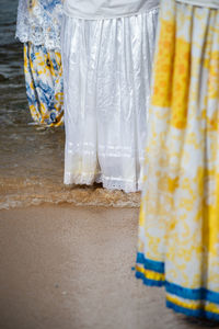 Person entering sea water wearing a long dress.