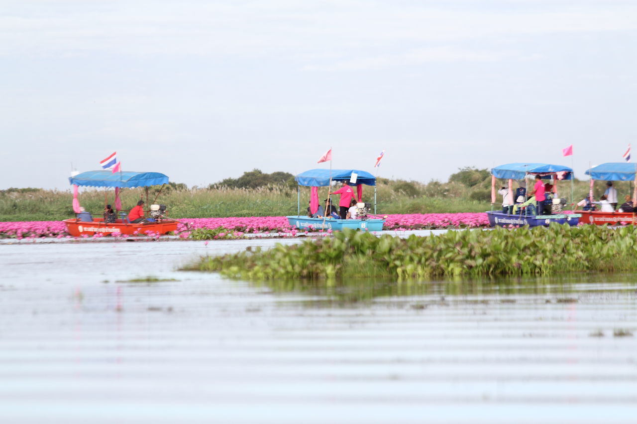 GROUP OF PEOPLE ON BEACH AGAINST SKY