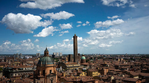 Aerial view of city buildings against cloudy sky