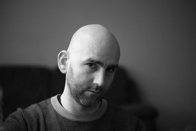 Close-up portrait of man standing against wall at home