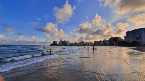 Panoramic view of people on beach against sky