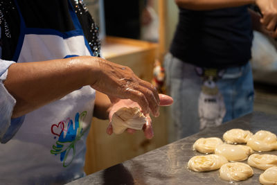 Midsection of people holding food at table