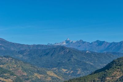 Scenic view of mountains against blue sky