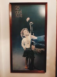 Cute boy holding toy while standing on table