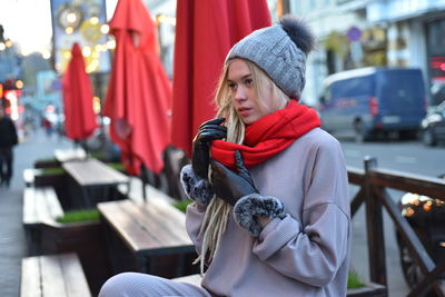 Woman looking away while sitting on bench