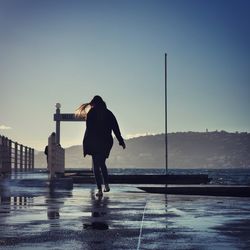 Rear view of woman walking on sea