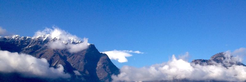 Scenic view of mountains against blue sky