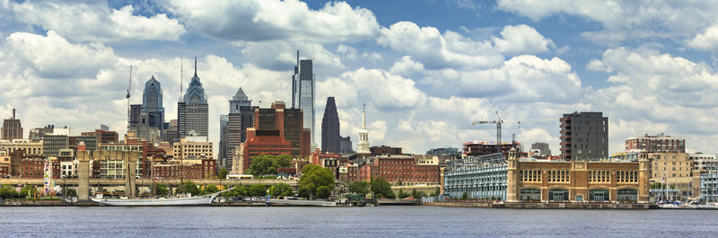 Panoramic view of buildings against cloudy sky