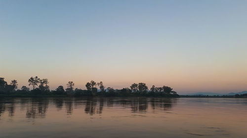 Scenic view of lake against sky at sunset