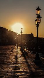 Silhouette of street light against sky at sunset