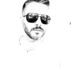 Portrait of man wearing sunglasses against white background