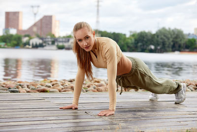 Side view of young woman exercising in sea