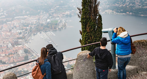 Rear view of people photographing while standing in city