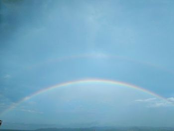 Low angle view of rainbow against blue sky
