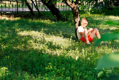 Portrait of young woman sitting on grassy field