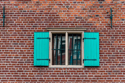 Blue window on brick wall of building