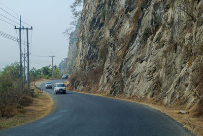 Road amidst rocks against sky