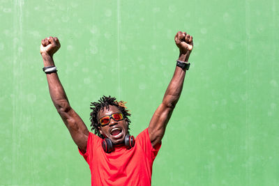 Portrait of young man with arms raised