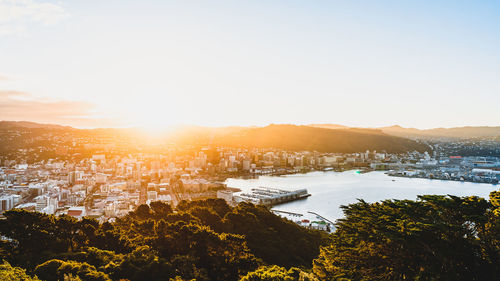 High angle view of buildings and trees against sky during sunset