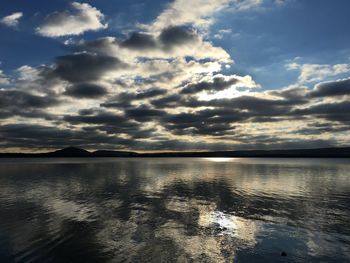 View of calm lake against cloudy sky