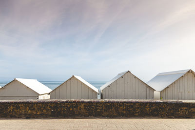 White beach huts in a brittany seaside resort. small wooden chalets on the coast