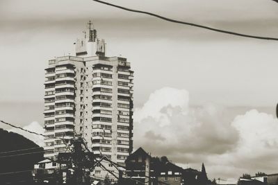 Low angle view of buildings against cloudy sky