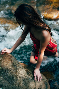 High angle view of woman leaning on rock
