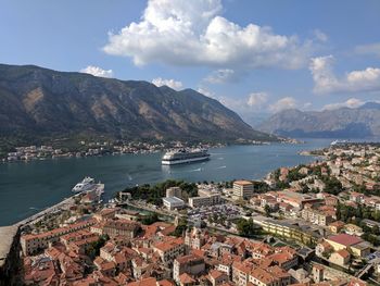 Aerial view of city by sea against sky