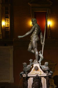 Low angle view of statue against illuminated building