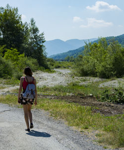 Rear view of woman walking on road