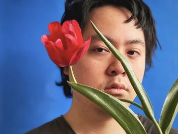 Close-up portrait of woman with red flower