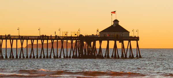 Pier over sea against sky during sunset