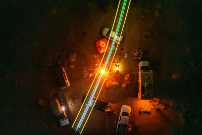 Aerial shot of campfire ring when friends are overland camping, with an rc plane lighting up the sky