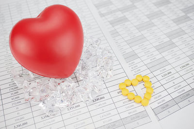 High angle view of heart shape with medicines on document